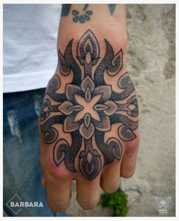 mandala mano Fotografia di una mano maschile con tatuato un mandala in stile ornamentale e dotwork, con colori nero e grigio pastello, eseguito da Barbara Schena presso lo studio Maia Tattoo di Milano Cornaredo