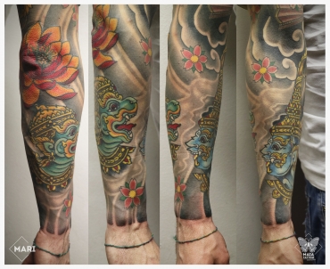 Tatuaggio in stile giapponese ornamentale su avambraccio, raffigurante guardiani induisti e un fiore di loto su gomito, eseguito da Marianna Bevilaqua 