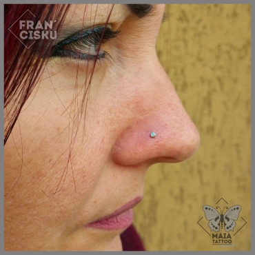 Fotografia di un Piercing alla narice (nostril) con gioiello in opale bianco, eseguito da Francesco Deschino allo studio Maia Tattoo di Milano Cornaredo